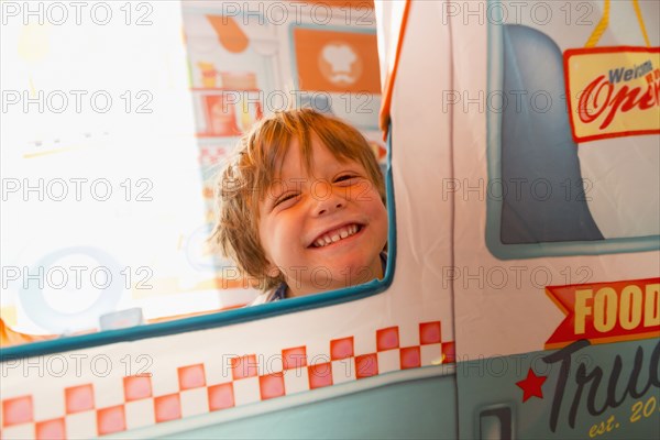 Portrait of smiling Caucasian boy in window