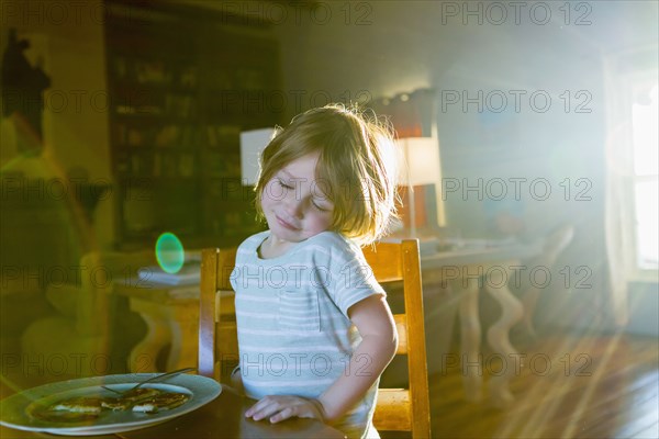 Sunshine on Caucasian boy eating food at table