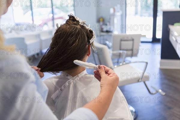 Stylist styling hair of woman