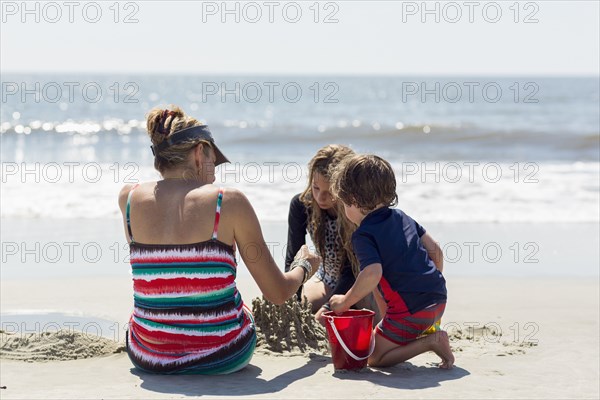 Caucasian family building sand castle at beach