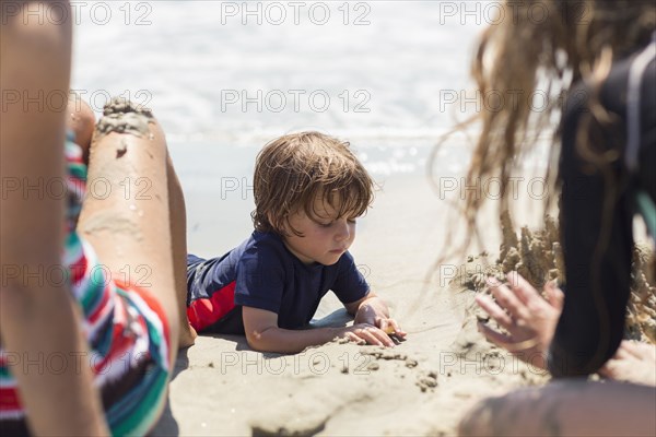 Caucasian family playing at beach