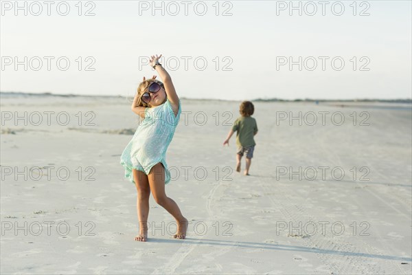 Caucasian girl posing with sunglasses on beach