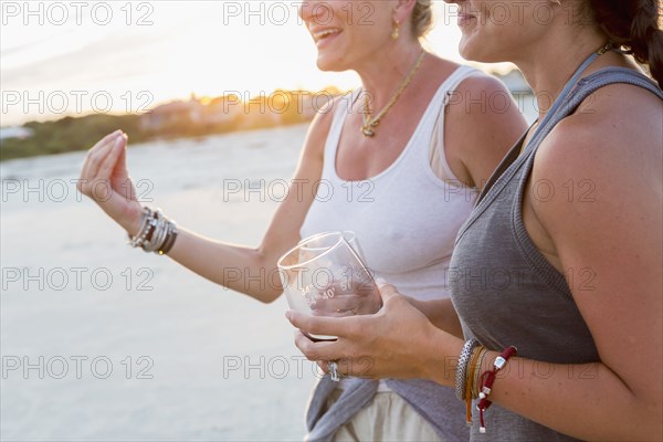 Caucasian women drinking wine on beach