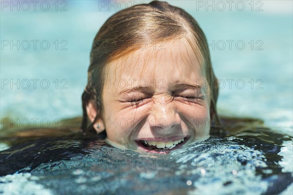 Caucasian girl swimming with eyes closed