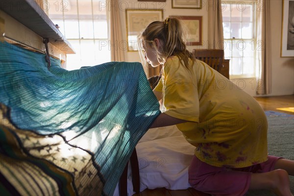 Caucasian girls building fort under table