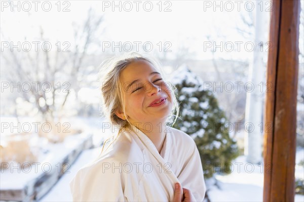 Caucasian girl wearing bathrobe laughing