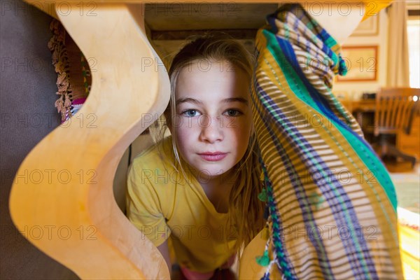 Portraits of serious Caucasian girl under table