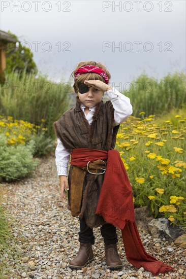 Caucasian boy wearing a pirate costume searching