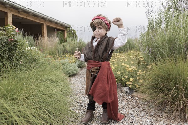 Caucasian boy wearing pirate costume holding knife