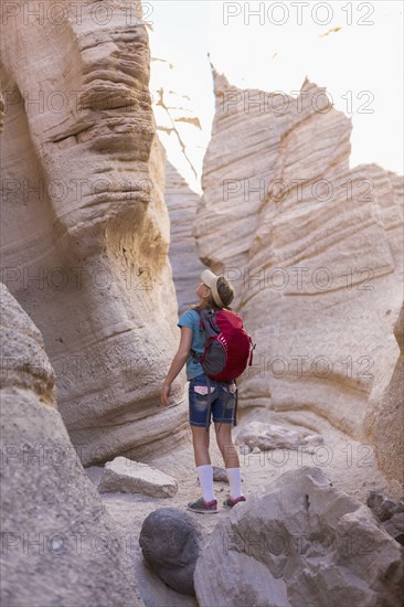 Caucasian girl looking up at rock formation