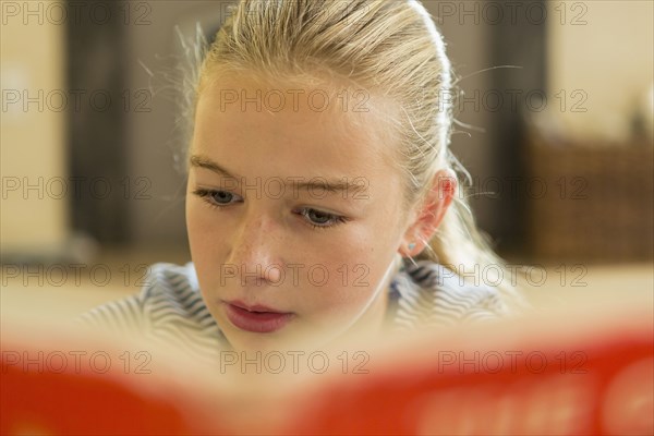 Close up of Caucasian girl reading book