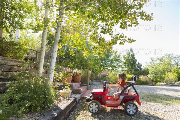 Caucasian boy driving toy car