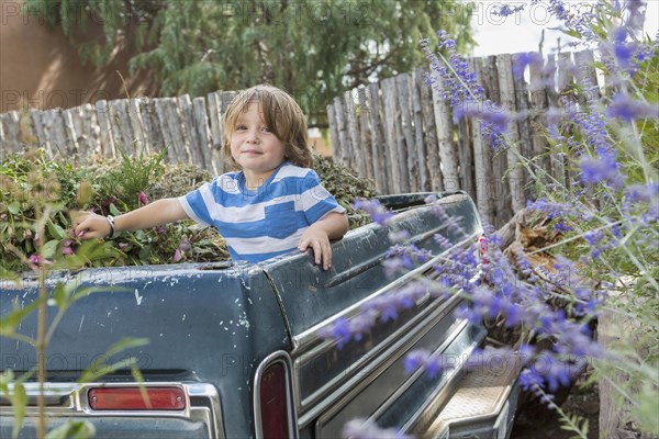 Caucasian boy playing in the truck bed