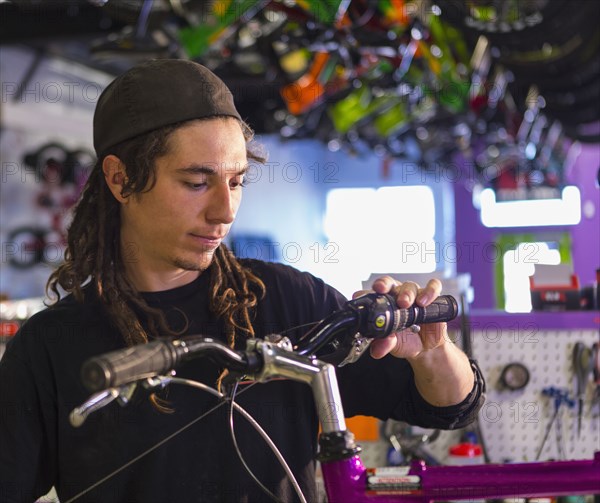 Man repairing bicycle in shop