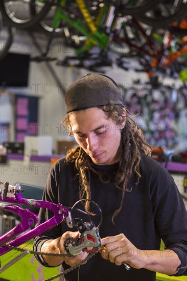 Man repairing bicycle in shop