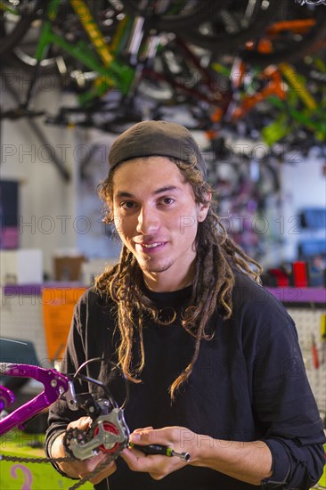 Portrait of smiling man repairing bicycle in shop