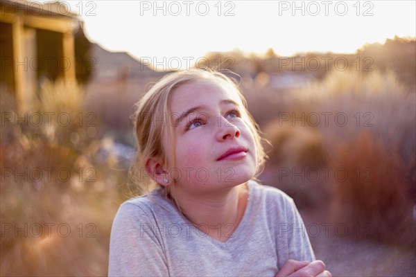 Curious Caucasian girl looking up outdoors