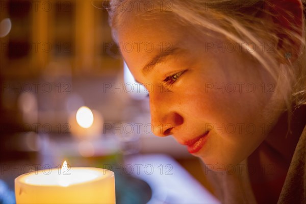 Smiling Caucasian girl watching candle