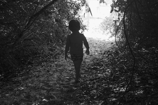 Caucasian boy walking on sandy path