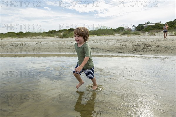 Caucasian boy running in water