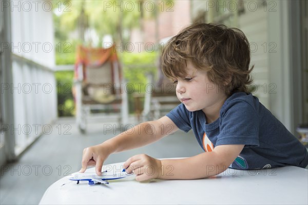 Caucasian boy playing with toy airplane