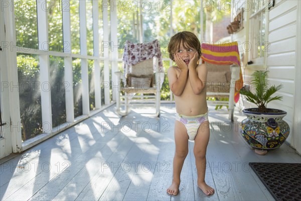 Caucasian boy on the porch wearing a diaper