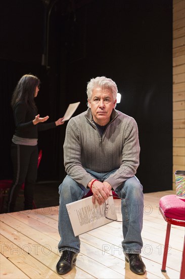 Hispanic man holding script on theater stage