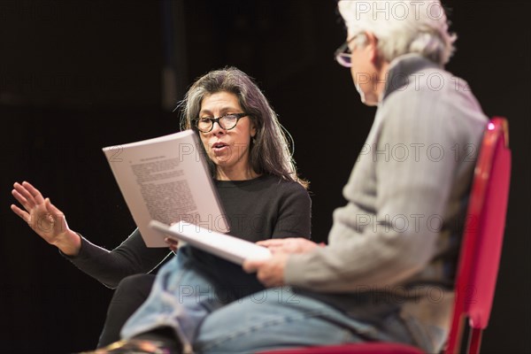 Hispanic man and woman reading scripts on theater stage