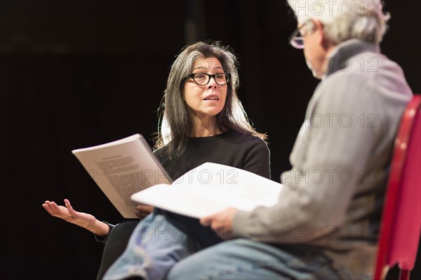 Hispanic man and woman reading scripts on theater stage