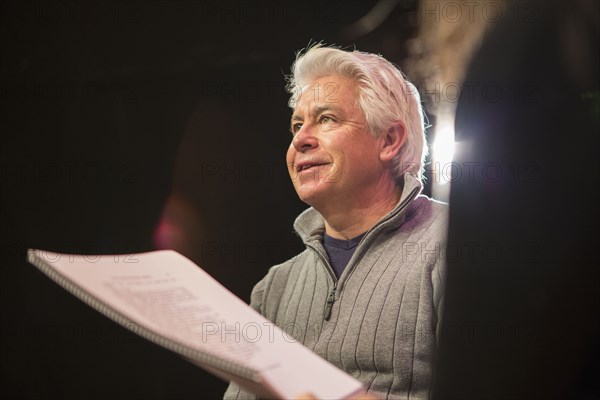 Hispanic man and woman reading scripts in theater