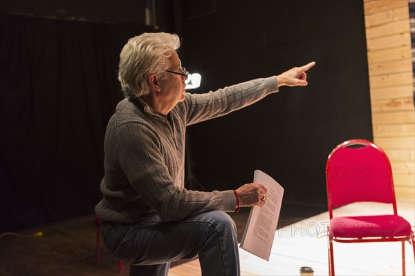 Hispanic man holding script pointing in theater