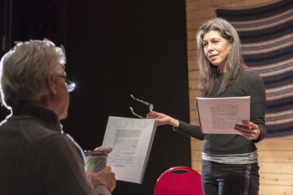 Hispanic man and woman reading scripts on theater stage