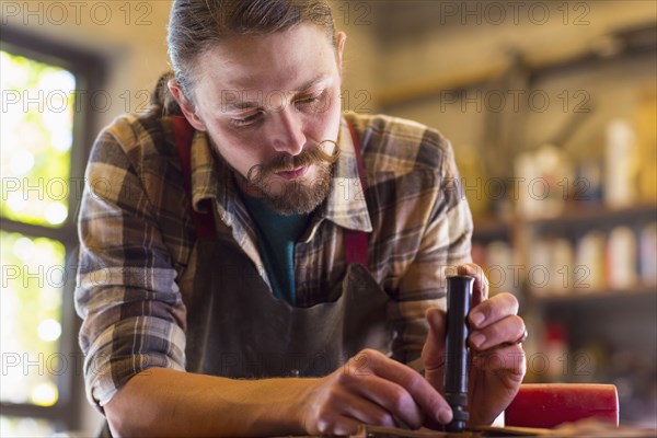 Caucasian man working on leather