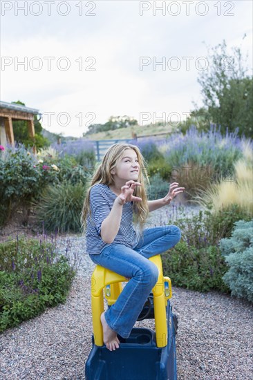 Fierce Caucasian girl sitting on toy car