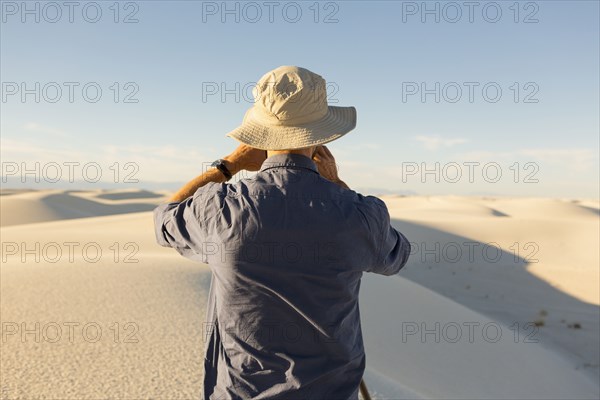 Caucasian man photographing a desert landscape