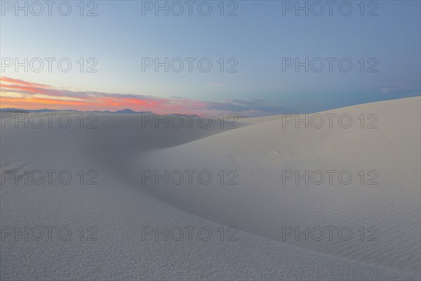 Sand dunes in desert at sunset