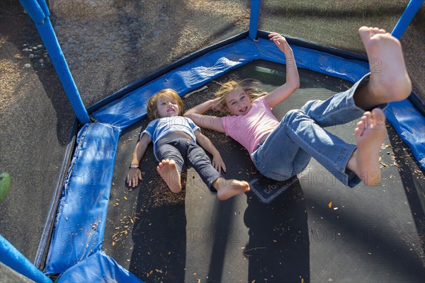 Caucasian brother and sister bouncing on trampoline