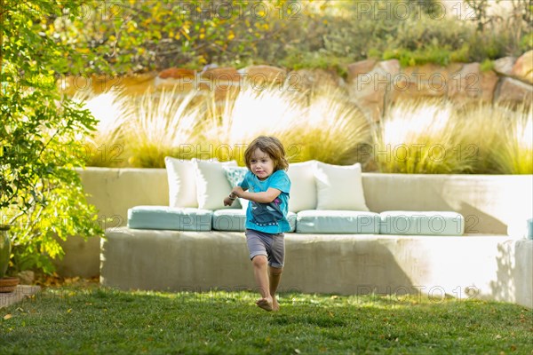 Caucasian boy running in backyard