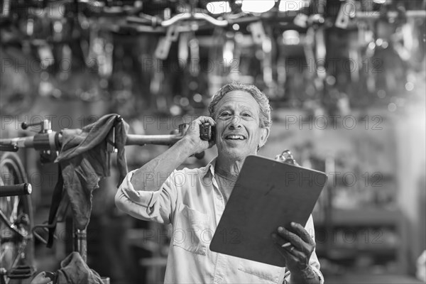 Caucasian man in bicycle shop talking on telephone