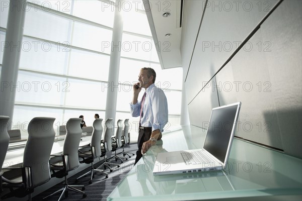 Businessman talking on cell phone in conference room