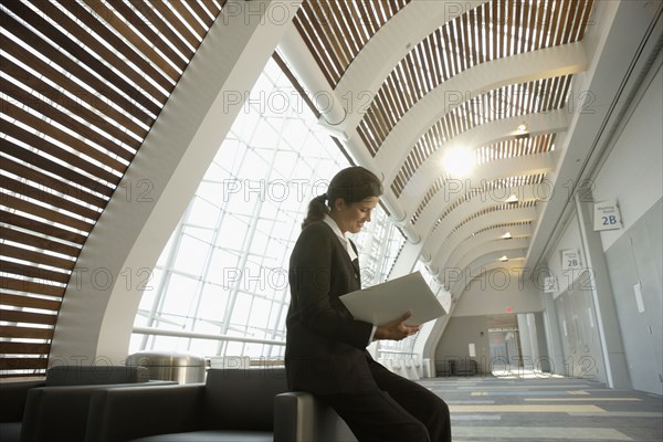 Businesswoman reading paperwork in conference room