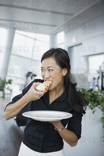 Asian woman eating pizza