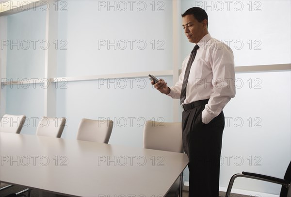 Hispanic businessman looking at electronic organizer