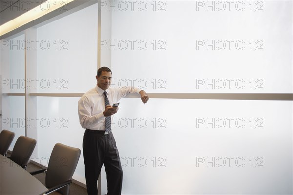 Hispanic businessman looking at electronic organizer