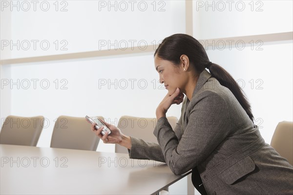 Asian businesswoman looking at electronic organizer