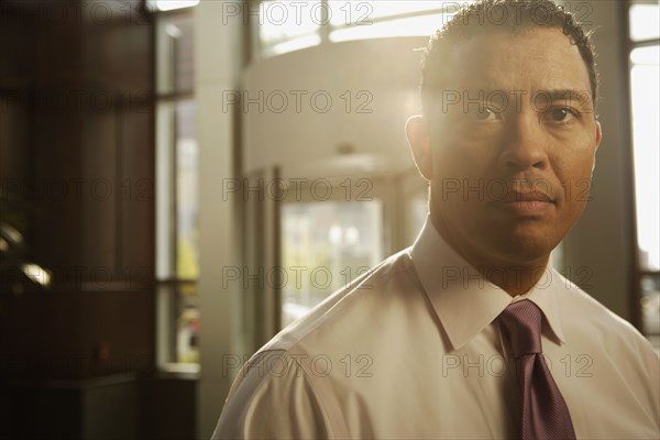 Portrait of Hispanic businessman in sunlight