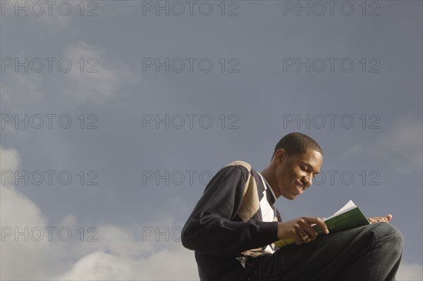 African man reading outdoors