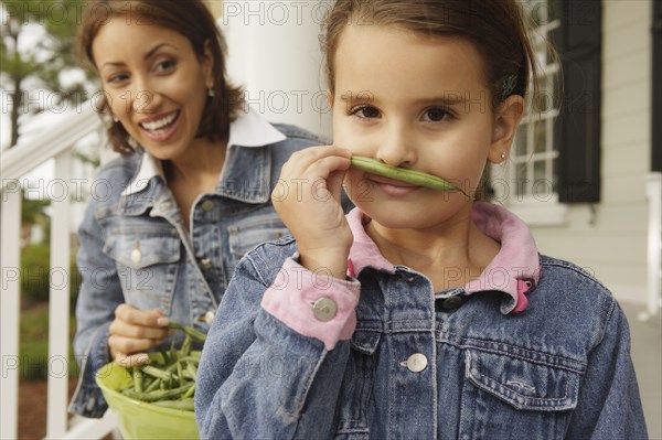 Hispanic mother and daughter with fresh green beans