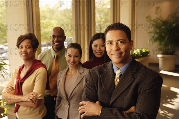 Hispanic businessman in front of coworkers