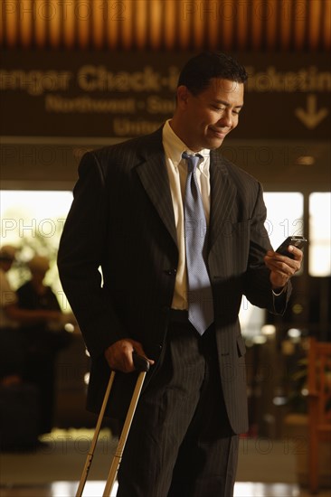 Hispanic businessman looking at cell phone